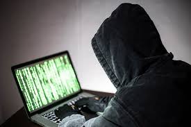 [ID: Graphic showing a hacker at a computer]